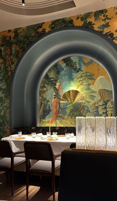 a dining room with tables and chairs in front of a mural