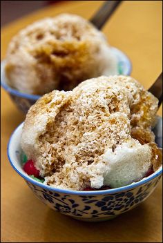 two bowls filled with ice cream on top of a wooden table