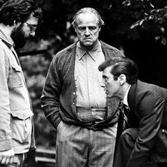 three men standing next to each other in front of trees