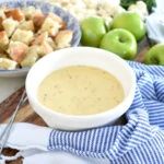 there is a bowl of soup on the table next to some apples and other foods