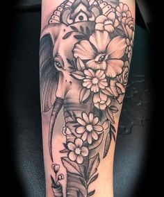 an elephant and flowers tattoo on the leg