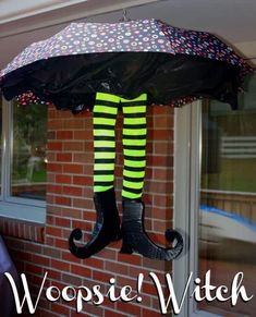 an upside down umbrella hanging from the side of a brick building next to a window