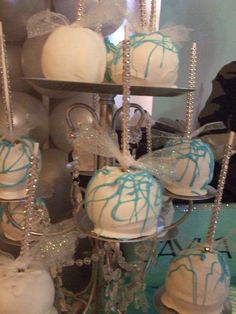 there are many white and blue cakes on the trays with silver candlesticks