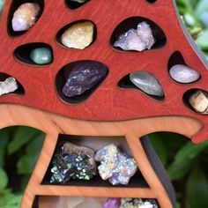 a wooden stand with rocks and crystals in it