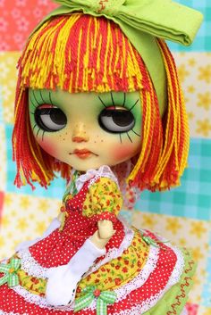 a close up of a doll with green eyes and red hair, wearing a dress