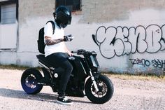 a man sitting on top of a black motorcycle