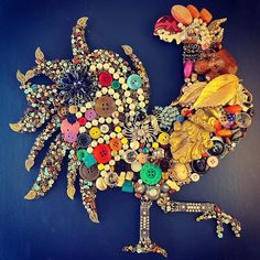 a rooster made out of buttons on a blue wall