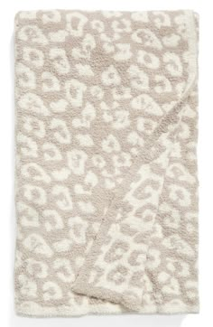 the leopard print blanket is shown in beige and white, with an animal pattern on it