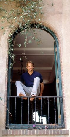 a man sitting in the window of a building