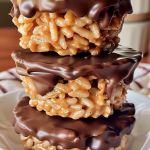 three chocolate covered treats stacked on top of each other in a white plate with napkins