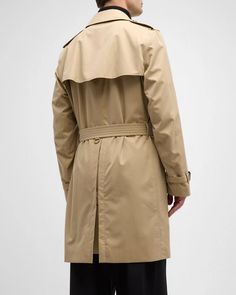 Burberry 'Kensington' trench coat made from water-resistant gabardine.Hook-and-eye collar closure​.Throat latch.Shoulder epaulettes​.Belted waist and cuffs.Side button welt pockets​.Center back vent.Burberry Check lining and undercollar​.Buckles: calf leather Cotton Lining: Cotton/viscose Made in United Kingdom Model is 6'1'/185cm. Burberry Kensington Trench Coat, Shoulder Epaulettes, Burberry Coat, British Heritage, Cotton Viscose, Global Brands, Burberry Men, Welt Pockets, Welt Pocket