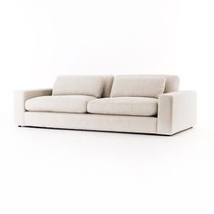 a white couch sitting on top of a white floor