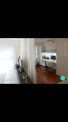 a living room filled with furniture and a flat screen tv sitting on top of a wooden floor