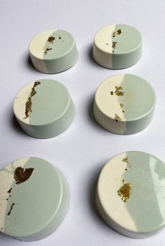 six white and gold plates with holes in them