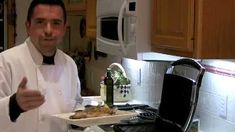 a man in a chef's outfit is giving the thumbs up while standing next to a stove