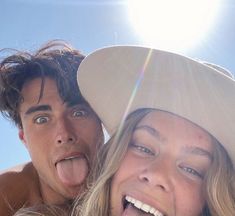 a man and woman are making funny faces while posing for the camera with their tongue hanging out