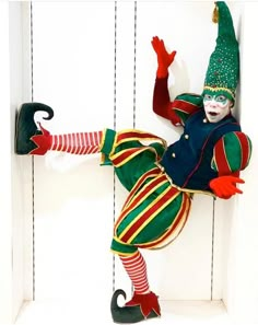 a clown is hanging upside down on the wall