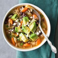 a bowl of soup with carrots, black beans and avocado