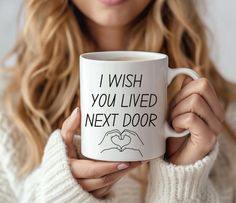 a woman holding a coffee mug that says i wish you lived next door