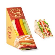 a sandwich in a cardboard box next to a cut in half sandwich with rainbow toppings