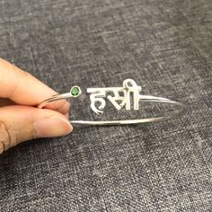 "Personalized Hindu Name Bracelet is handmade with its own uniqueness. It can be bought as a gift for any occasion like birthday gift, wedding gift, travel gift, souvenir and etc. If you need rose gold plating or yellow gold plating, please contact us, we will advice you on the additional fees applicable. Base Material: Sterling Silver Size: 11mm (Approximately) Bangle wrist size: 7'' - 8'' Inches. Adjustable / Please give us your wrist circumference. Stone: Red CZ setting (Default) Or check wit Handmade Name Bracelet For Mother's Day, Customized Bangle Name Bracelet As Gift, Customized Bangle Name Bracelet For Gift, May Birthstone Bangle Jewelry Gift, Customized Name Bangle Bracelet For Gift, May Birthstone Bangle For Gift, Initials Bracelet Jewelry Gift, Spiritual Jewelry With Custom Name For Gift, Customized Bangle Bracelet For Gift