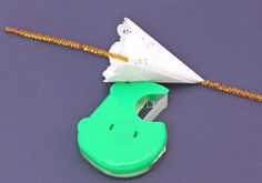 a green and white object on a purple surface next to a yellow string that is attached to it