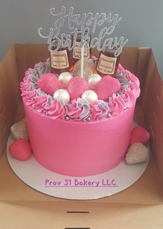 a pink birthday cake in a cardboard box