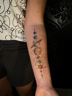 a woman with a tattoo on her arm that has planets and stars in the sky