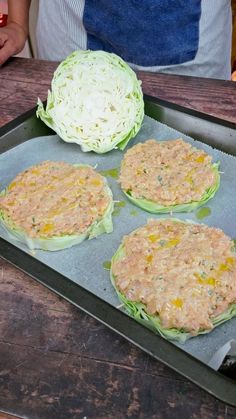 three hamburger patties on a baking sheet with lettuce and cheese in the middle