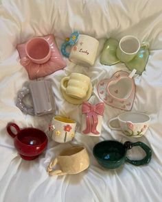 there are many different cups on the bed