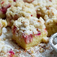 a close up of a dessert with powdered sugar on top and raspberry crumbs