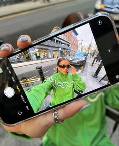 a person holding up a cell phone to take a selfie with the camera on