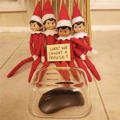 three elfs sitting on top of a mouse pad with a sign that says, look we caught a mouse