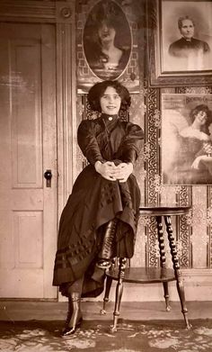 an old black and white photo of a woman sitting on a chair