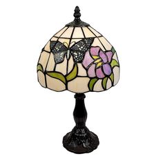 a stained glass lamp with flowers and butterflies on the top, sitting on a black base