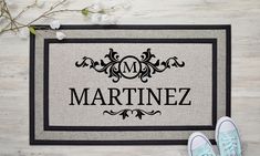 a door mat with the name martinez on it next to sneakers and flowers