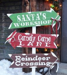 three wooden signs that say santa's workshop, candy cone lane and reindeer crossing