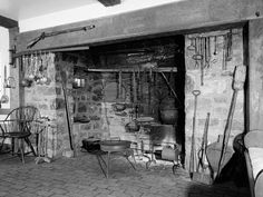 an old fireplace with pots and pans hanging from it's sides in a living room