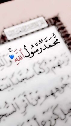 an arabic text is displayed on a piece of paper with blue heart in the middle