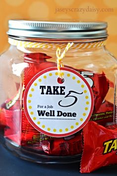 a jar filled with red and yellow candies next to a tag that says take 5 for a job well done