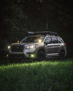 a car parked in the grass with its lights on