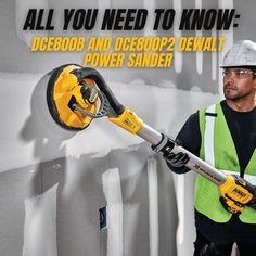 a man in safety gear is holding a power tool and standing next to a wall