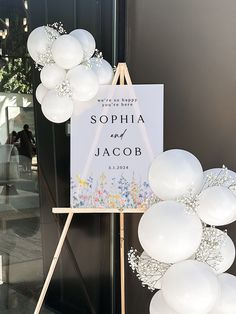 a sign with balloons attached to it sitting in front of a door that says sophia and jacob