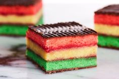 three different colored desserts sitting on top of a marble countertop next to each other