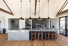 a large kitchen with an island and three stools