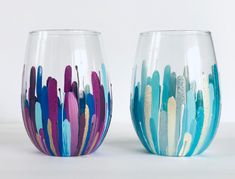 two wine glasses with different colored designs on them