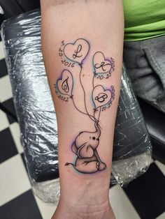 an elephant with balloons tattoo on the arm