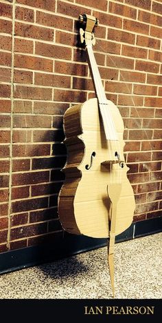 a violin leaning against a brick wall with the words, i am pearson on it