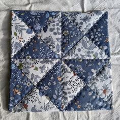 a blue and white patchwork quilt with flowers on it