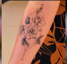 a woman's arm with roses on it and an arrow in the middle is shown